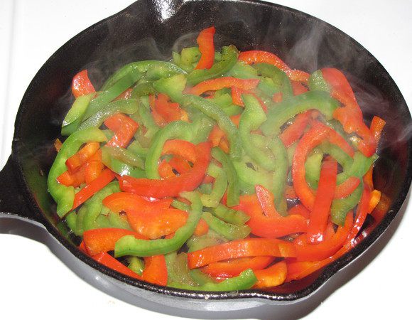 Стручки перца разрезать вдоль на четыре части и каждую четвертинку нашинковать лапшой. Слегка потушить перцы в оставшемся масле.