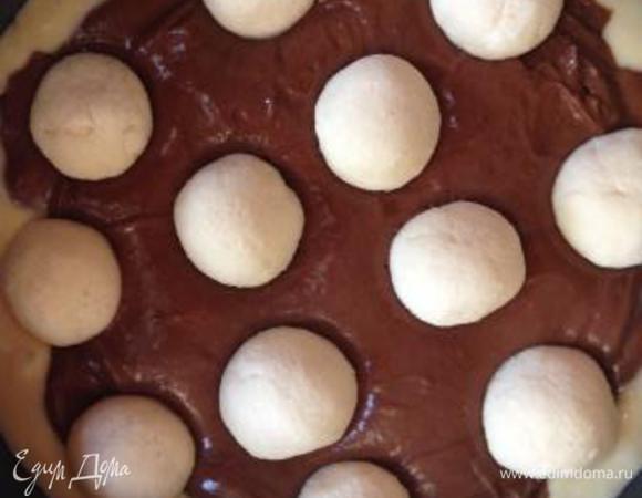 В форму, выложенную пергаментом или смазанную маслом, выливаем сначала белое тесто. Сверху распределяем темное тесто - можно равномерно, вторым слоем, можно фигурно, в виде цветка - по вашей фантазии и усмотрению. И на темное тесто выкладываем наши творожно-кокосовые шарики, слегка вдавливая их в тесто.