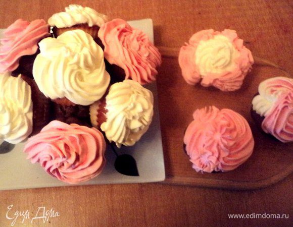 При помощи кондитерского шприца нанести крем на капкейки в виде лепестков роз. На шоколадные капкейки – розовый крем, на белые - белый крем. 