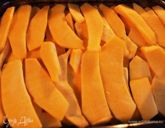 Спустя 30 минут на курицу ровным слоем выкладываем тыкву и возвращаем запекаться еще на 20 минут.