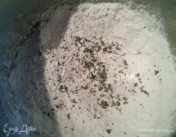 Смешайте оба вида муки, одну ложку отложите в сторону. Добавьте травки. 