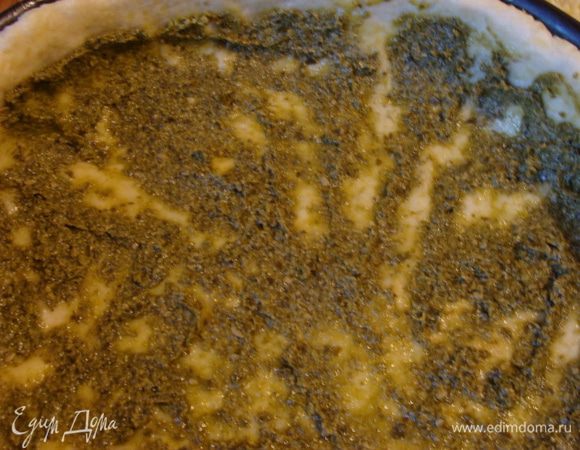 Достать форму с тестом из морозилки, распределить равномерно соус песто по дну и бортиками.