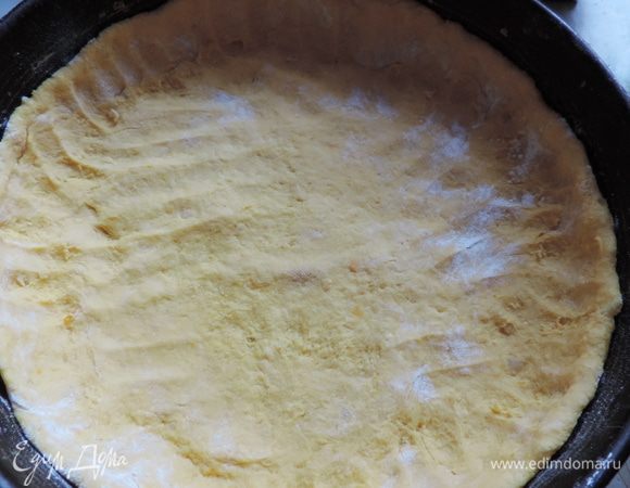 Распределяем тесто по форме диаметром 26см, дно которой выстелено бумагой, бортики можно смазать маргарином или растительным маслом. Формируем из теста небольшие бортики.