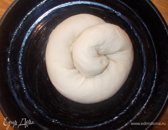 Завернуть его по кругу,поджав под низ кончики. Выложить его на противень смазанный маслом. Поставить в теплое место,чтобы наш пирог подошел в два раза.Когда пирог подойдет,смазать его взбитый яйцом.