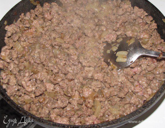 Добавить фарш, увеличить огонь и обжаривать, перемешивая и разбивая комки ложкой, до изменения цвета (примерно 4 минуты).
