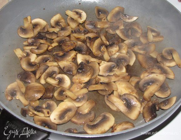 Шампиньоны разрезать пополам, а затем — небольшими дольками. Обжарить в отдельной сковороде в небольшом количестве масла на сильном огне до румяной корочки.