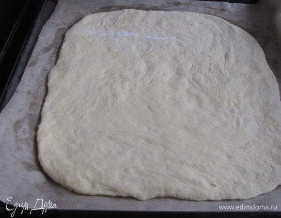 Раскатать тесто в квадрат или прямоугольник, положить на застеленный пергаментом противень.