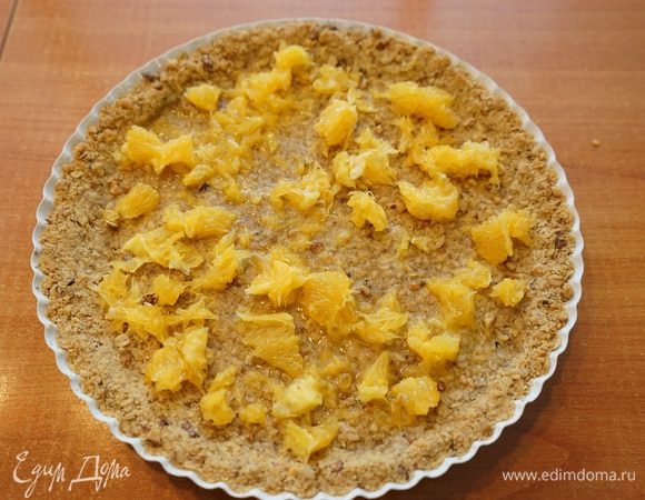 Теперь самое сложное: трём на мелкой терке цедру с двух апельсинов, откладываем на тарелку подсушиться. Очищаем апельсины от шкурки, пленок, перегородок и выкладываем порезанную мякоть на запеченную основу в форму.