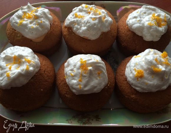 Через 15 мин. достаем капкейки из холодильника и с помощью фигурной насадки украшаем верх каждого кексика итальянской меренгой и посыпаем апельсиновой цедрой.