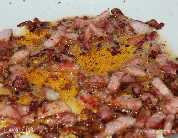 Режем бекон, добавляем к салу и тоже хорошо поджариваем. Добавляем перец чили, перемешиваем. Добавляем паприку, мелко посеченный чеснок, перемешиваем и выключаем огонь. 