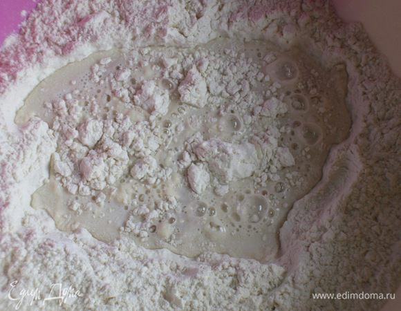 Муку высыпать на рабочую поверхность, сделать в центре углубление и влить дрожжи. Замесить тесто.