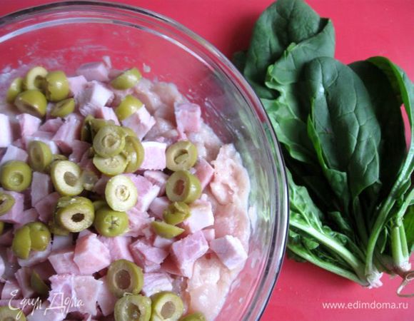 Добавить порезанные колечками оливки и порезанную кубиками варено-копченую грудинку. 