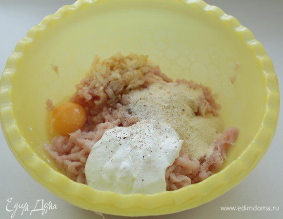 Лук мелко порезать и спассеровать в сливочном  масле.
 В фарш добавить манку, сметану, яйцо, лук, раздавленный чеснок и зелень. Все посолить, поперчить и  хорошо перемешать.