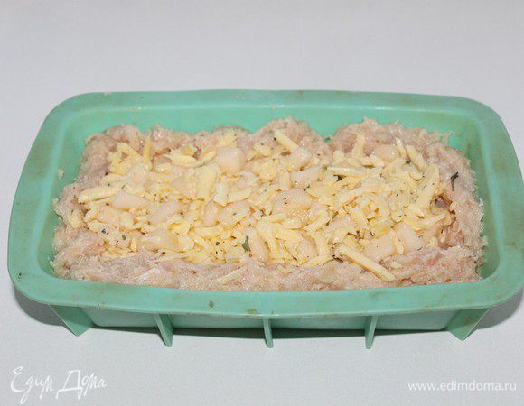 Отделить четвертую часть фарша ,отальным  выложить дно и бока формы.На фарш выложить начинку.