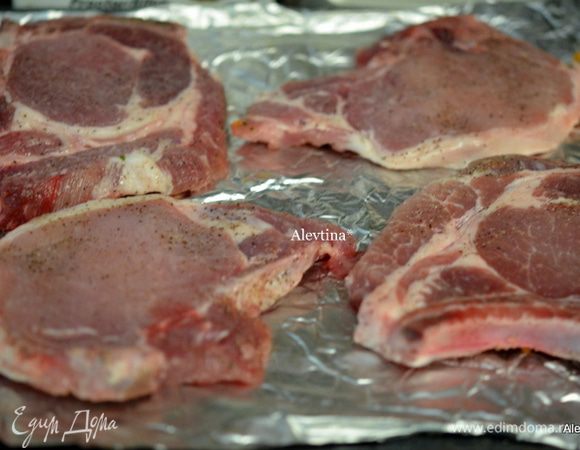 Посолить и поперчить свиные отбивные. Выложить на фольгу и отправить в разогретую духовку на 200 гр . Готовить 45 мин или до готовности, раз перевернув.
