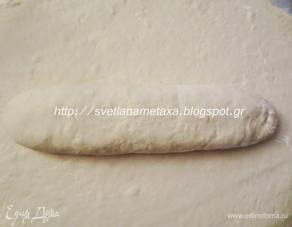 В середину раскатанного пласта положить рулет.