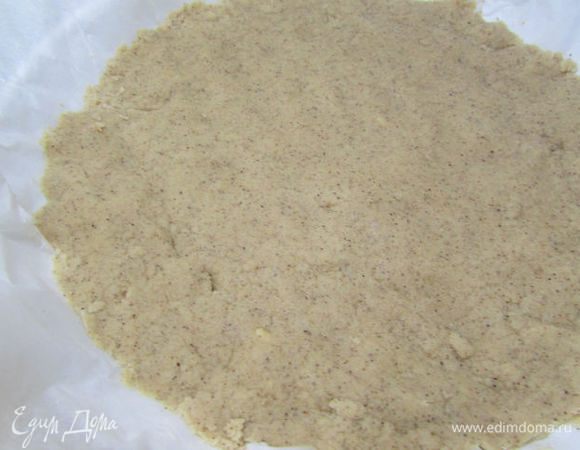 Форму для выпечки (22 см) смазать маслом, затем застелить пекарской бумагой и уложить на неё крошку, разровнять и хорошо утрамбовать.