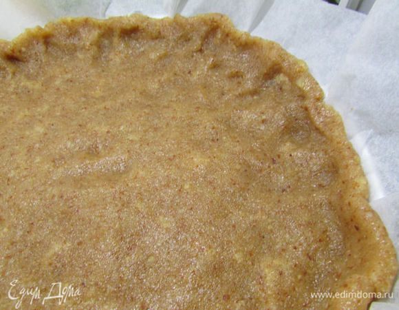 Марципановую основу раскатать между двумя целлофановыми пакетами в лепёшку и уложить поверх теста. Разровнять и сделать небольшие бортики.