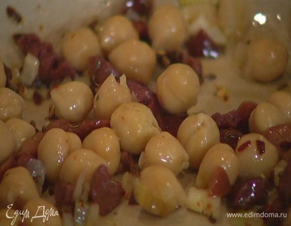 В сковороду с луком добавить оливки, нут, перемешать и прогревать буквально несколько секунд, затем переложить в другую посуду.