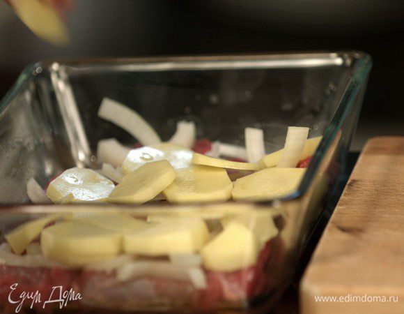 Картофель нарезаем кольцами и выкладываем в блюдо следующим слоем.