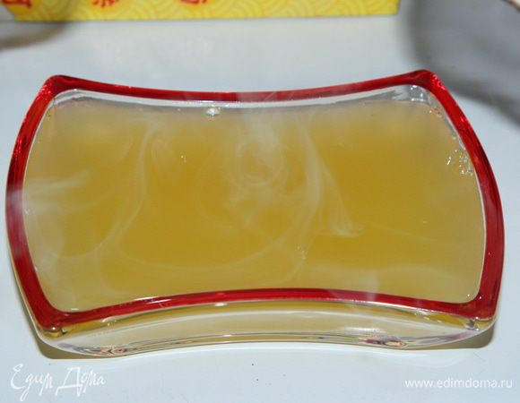 К содержимому 1 пакетика желе для торта добавляем 1 неполную столовую ложку сахара, перемешиваем и высыпаем в закипевшую воду, кипятим 1 минуту, помешивая. Затем вливаем апельсиновый сок, добытый из 1 апельсина (у меня это 75 мл), доводим снова до кипения и выключаем. Выливаем в подходящую посуду и отправляем на холод остывать и желироваться. Вот получилось так красиво и солнечно.