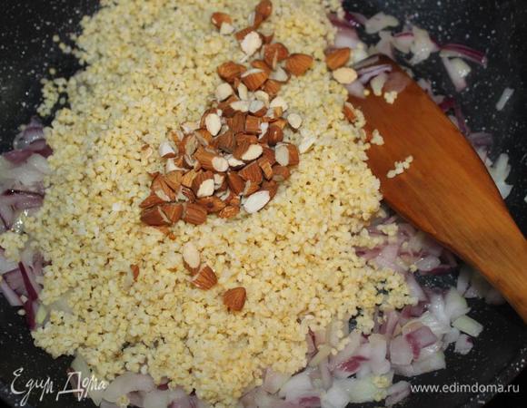 Половину срезанных частей лука измельчаем. 
В сковороде разогреваем масло и обжариваем лук минут 5.
А пока крупно рубим орехи. Очень к месту будут лесные или грецкие, у меня был миндаль.  
Добавляем к овощам сваренное и сцеженное от лишней жидкости пшено и орехи.