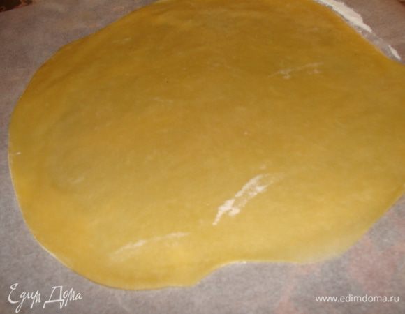 Делим тесто на 6-7 частей. Раскатываем на пергаменте скалкой. Диаметр 24 см.Кладем пергамент с коржом на противень. Накалываем вилкой.  Ставим в разогретую до 180 духовку.