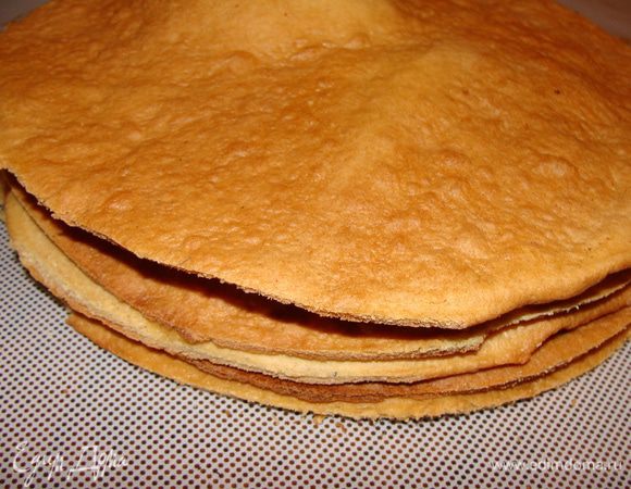 Выпекаем около 10 мин до золотистого цвета. Пока корж горячий, он мягкий, не крошится. Кладем на него крышку или дно формы для выпечки и обрезаем крач ножом. Обрезки нам потом пригодятся для обсыпки боков торта.
Я делаю сразу три коржа. Пока один в духовке, другой раскатываю, третий обрезаю.