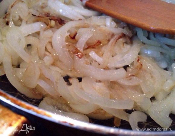 Тем временем, порезать луковицу полукольцами, чеснок измельчить и поджарить до прозрачности на оливковом масле.