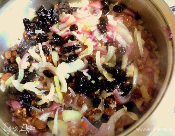 Чернослив и изюм промыть горячей водой, чернослив порезать небольшими кусочками. Добавить изюм и чернослив к луку и тушить под крышкой 5 минут.
