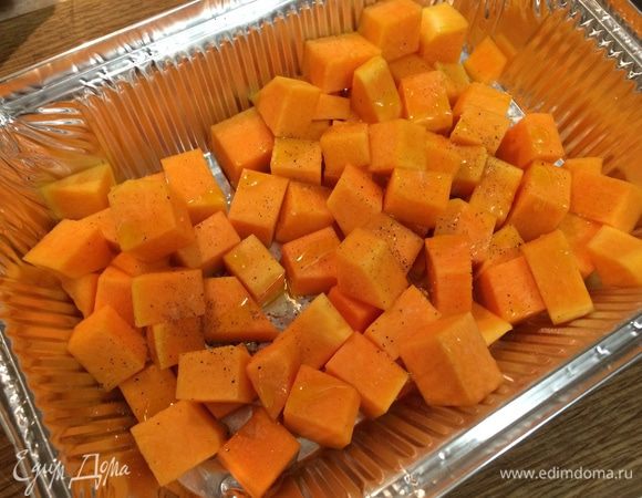 Разогреть духовку до 200С. Тыкву очистить от семян и кожуры, нарезать мякоть кубиками среднего размера. Выложить тыкву в форму для запекания, сбрызнуть 1 ст.л. оливкового масла, посыпать солью и свежемолотым черным перцем и отправить в разогретую духовку. 
Запекать тыкву для салата около 15 минут.