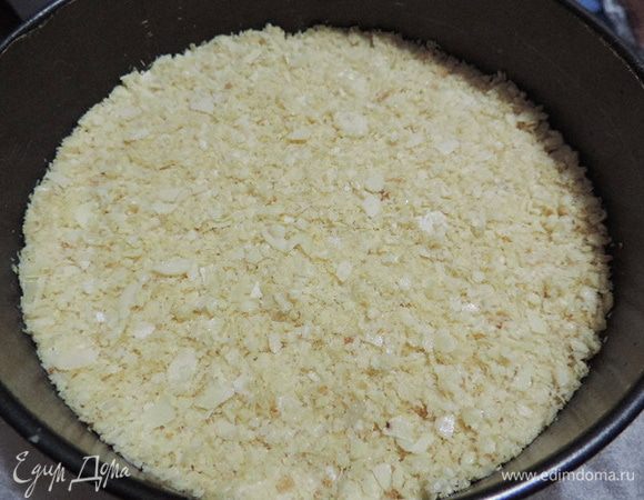 К этому времени у нас уже готова разъемная форма диаметром 22 см, дно которой выстелено пергаментом. Выкладываем туда шоколадную смесь, разравниваем, тщательно утрамбовываем и отправляем в холодильник.