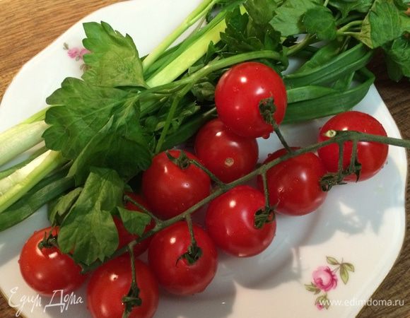 Помидоры черри и зеленый лук вымыть, лук измельчить, а помидоры разрезать на половинки. Выложить к тыкве зеленый лук и помидоры черри, снова отправить в духовку.
Запекать овощи еще 15-20 минут до мягкости тыквы. 