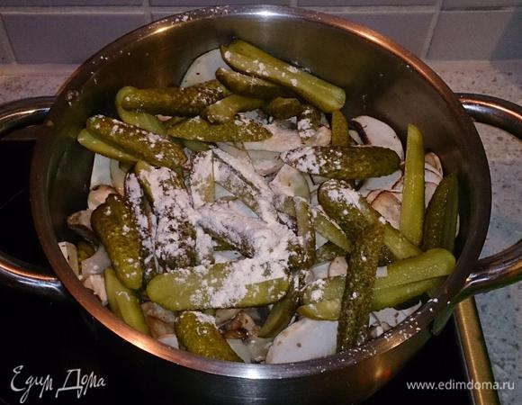 В кастрюлю выложить лук, шампиньоны, огурцы, посыпать мукой. Залить мясным бульоном и тушить на медленном огне 15 минут.