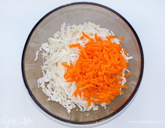 Белокочанную капусту тонко шинкуем. Добавим чуть-чуть соли и помнем руками. Морковь натрем на мелкой терке.