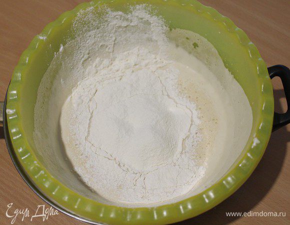Постепенно по частям добавить просеянную муку с содой и солью и перемешать лопаткой.