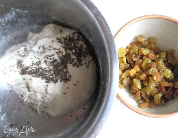  К тесту добавить тмин, изюм, хорошо перемешать. Накрыть посуду с тестом полотенцем на 1 час.