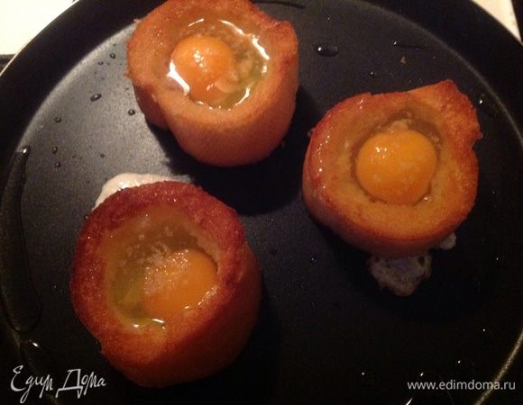 Обжариваем одну сторону багета на растительном масле, переворачиваем на другую сторону и вбиваем в середину багетов  по яйцу, тут их подсаливаем.