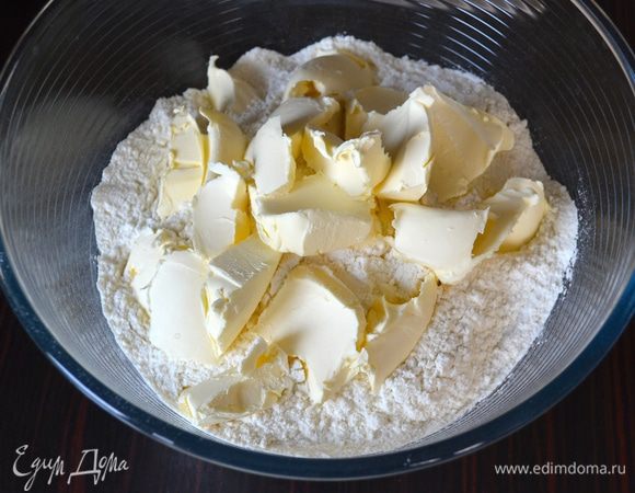 В большую миску просеять муку и добавить кусочки сливочного маргарина.