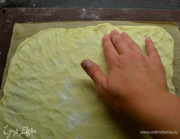 Тем временем достаем тесто из холодильника и делим на 7–8 частей. Духовку разогреть до 180°C. Далее раскатываем коржи очень тонко на пекарской бумаге! Я делаю так — вырезаю из бумаги сразу два прямоугольника (размером примерно 27*33 см). Пока выпекается один корж, занимаемся раскатыванием другого. Можно помогать себе немного пальцами рук. Раскатанный корж накалываем по всему периметру вилкой. Выкладываем на противень...