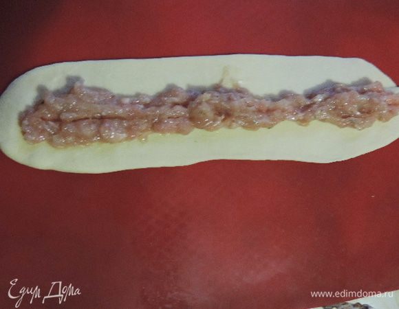 Теперь можно приступить к формированию "улиток". Берем кусочек теста размером чуть больше грецкого ореха. Раскатываем его в прямоугольник примерно 5*20см. По средине по всей длине прямоугольника не доходя до краев выкладываем примерно по две чайные ложки начинки.