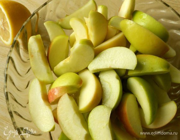 Яблоки помыть, обсушить, разрезать на четвертинки, удалить семена. Затем каждый кусочек разрезать ещё на 2-3 части, сложить в миску и смешать с лимонным соком.