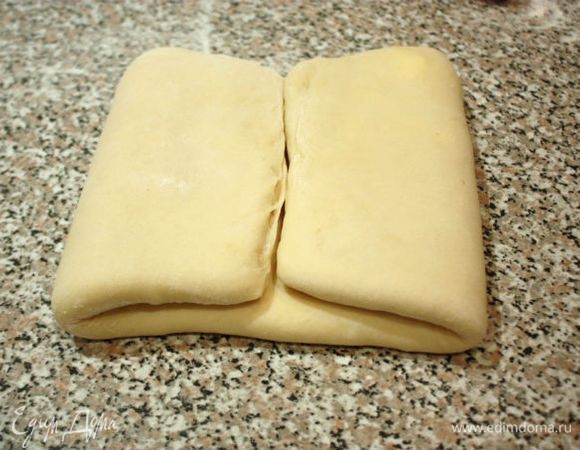  Затем переложить тесто на присыпанную мукой поверхность и раскатать до 20х45 см.Сложить в 4 слоя: сначала от краёв к центру,