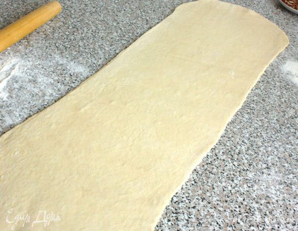 Тесто раскатать в  пласт шириной 24 см и разрезать вдоль на 2 полосы по 12 см. Пока работаете с одной полосой, вторую накройте пищевой плёнкой.