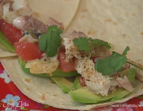 На горячие тортильи выложить авокадо, мякоть грейпфрута (сок сохранить), кусочки рыбы и листья кинзы.