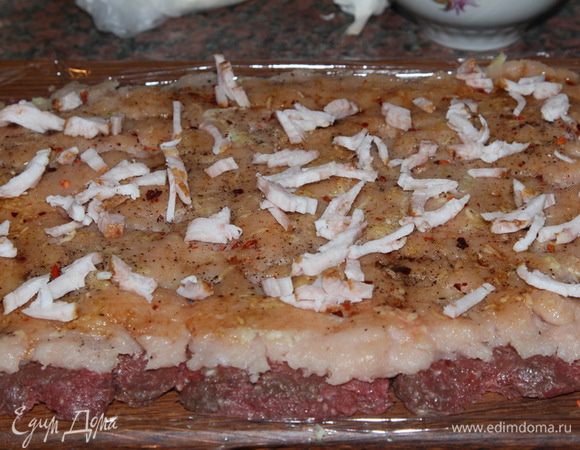 очень мелко нарезаем сало и распределяем его по поверхности мясного пласта