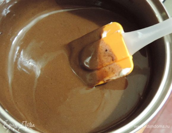 Пока бисквит печется, в ковшик положим шоколад и сметану и на среднем огне при постоянном помешивании растопим шоколад.
