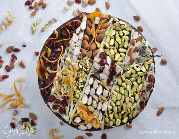 Торт переложить на блюдо для подачи и покрыть темной шоколадной глазурью сверху и с боков при помощи силиконовой лопатки. Затем с помощью кондитерского мешка нанести украшение из белой глазури. Конд. мешка у меня нет, я переложила глазурь в файлик (для документов), он достаточно плотный (лучше, чем просто пакетик) и у него легко можно отрезать уголок. Нарисовать белой глазурью контуры отдельных сегментов (или любой рисунок, какой пожелаете). Некоторые части  покрыть белой глазурью полностью. Затем выложить в каждой из частей свои украшения. 