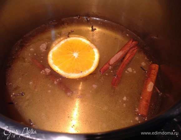 Добавьте дольки апельсина, специи и нагревайте на среднем огне, не доводя до кипения.