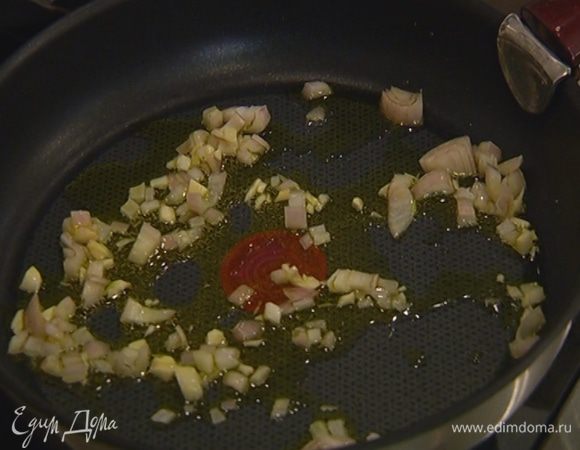 Разогреть в сковороде оливковое масло и обжарить лук до прозрачности, затем добавить чеснок, все перемешать и готовить еще пару минут.